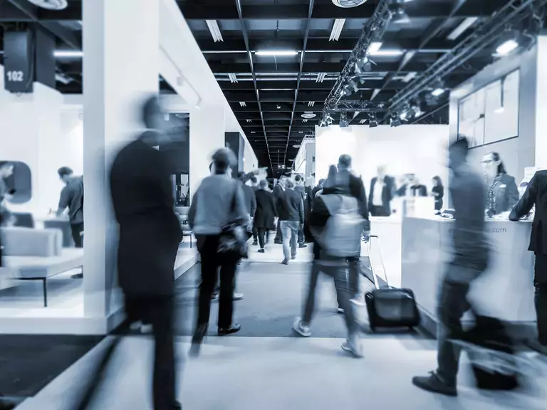 Blurred people walking through an exhibition hall