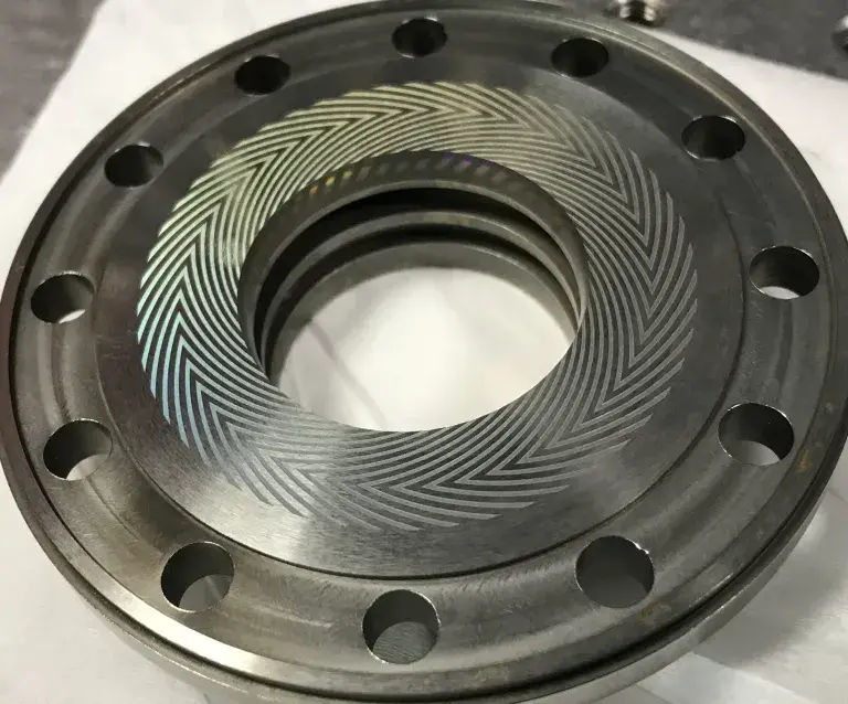 Molybdenum cylinder with chevron pattern grooves laser-machined along the circumferential surface