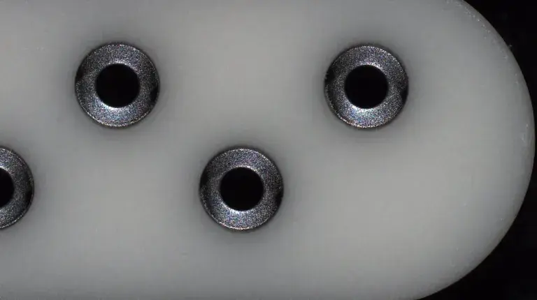 Selectively machined titanium plated ceramic plate.