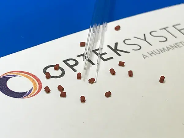 Laser-machined silicone gaskets (0.64mm OD – 0.125mm ID) compared with 125 µm fiber-optic strands.