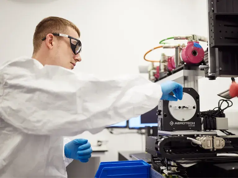 OpTek laser technician operating laser machine in lab coat