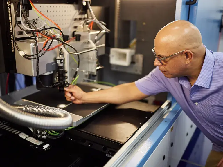 OpTek engineer inspecting inside laser machine