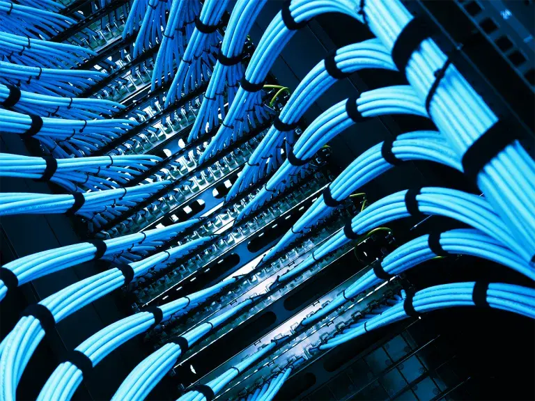 Intricate Network Cabinet with Blue Cables and Organized Wiring Layout