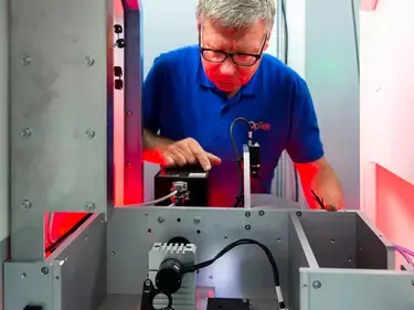 Engineer looking into OpTek Laser machine